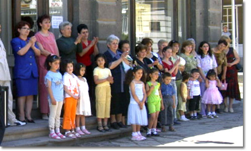 Staff, Relatives, and Students of the Aesthetic Educational Center of Gyumri watch and keep time as older students perform a welcoming dance for Birthright Armenia visitors.